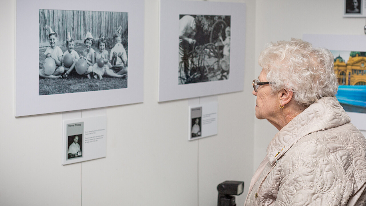 Joan Bates views images at WiCC's 50th Anniversary Launch