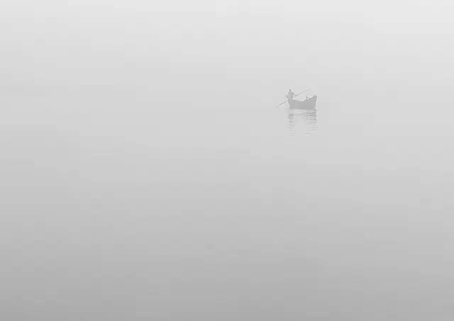 Fisherman veiled in Fog